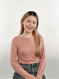 a young asian woman in a pink top and jeans